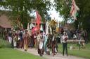 A procession walks through the grounds of Kentwell Hall in 2019