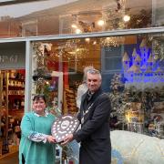 Town Mayor Peter Thompson presenting the shield for the best festive shop window to Romy Abraham from LOFT & SPIRES