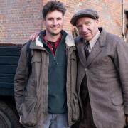 Jay Ducker (left) on set with Ralph Fiennes during filming for The Dig