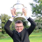 Sixteen-year-old Alfie Halil holds the Faraday Trophy above his head after winning the Suffolk Open Championship at Rookery Park on Sunday. Picture: TONY GARNETT